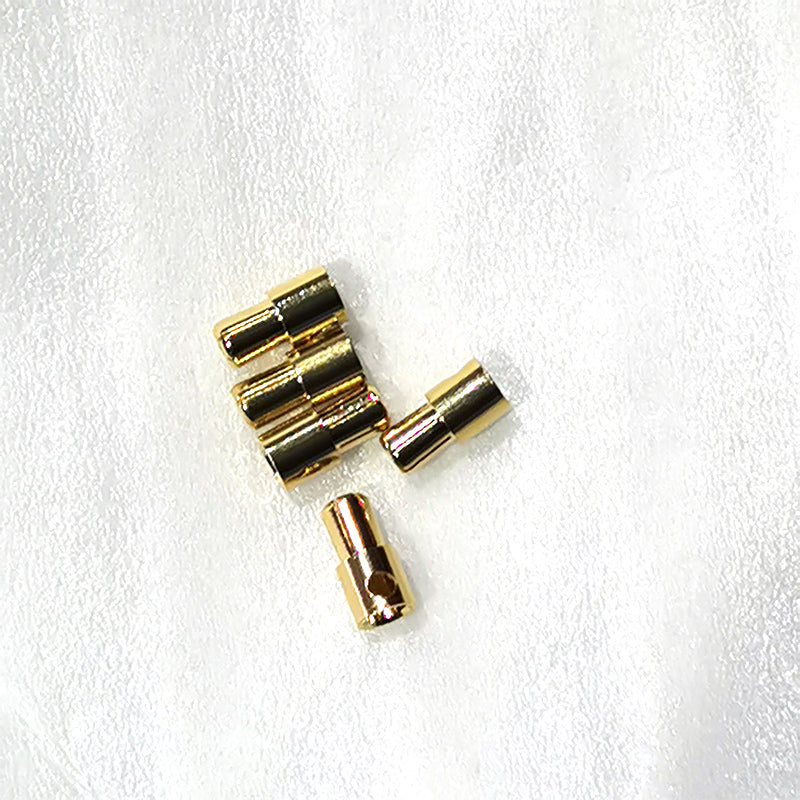Connecteurs mâles 5,5 mm dorés pour trottinette électrique Dualtron posés sur un fond blanc