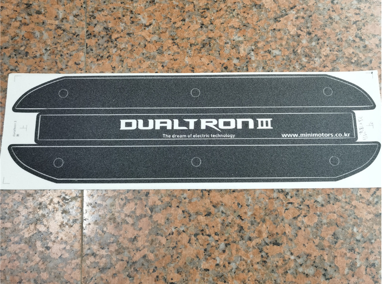 Grip antidérapant noir avec logo Dualtron III vu de haut sur planche de protection