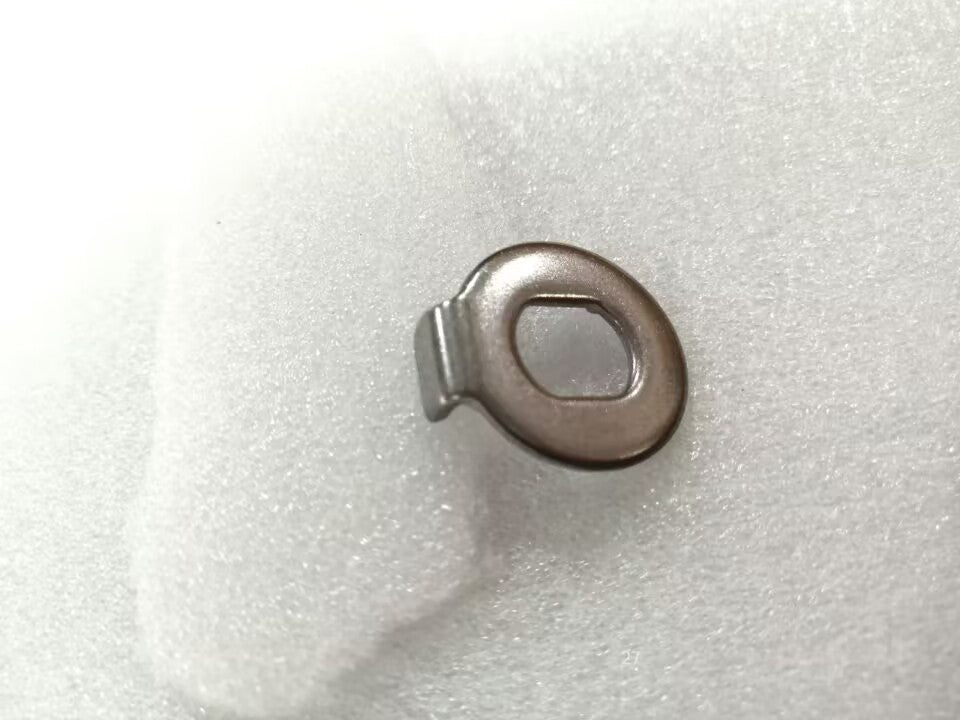 Rondelle anti-rotation métallique pour moteur posée sur un fond blanc