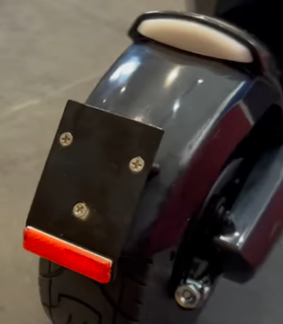 Garde-boue arrière noir équipé d'un support de plaque et d'un réflecteur rouge sur trottinette Dualtron Dolphin