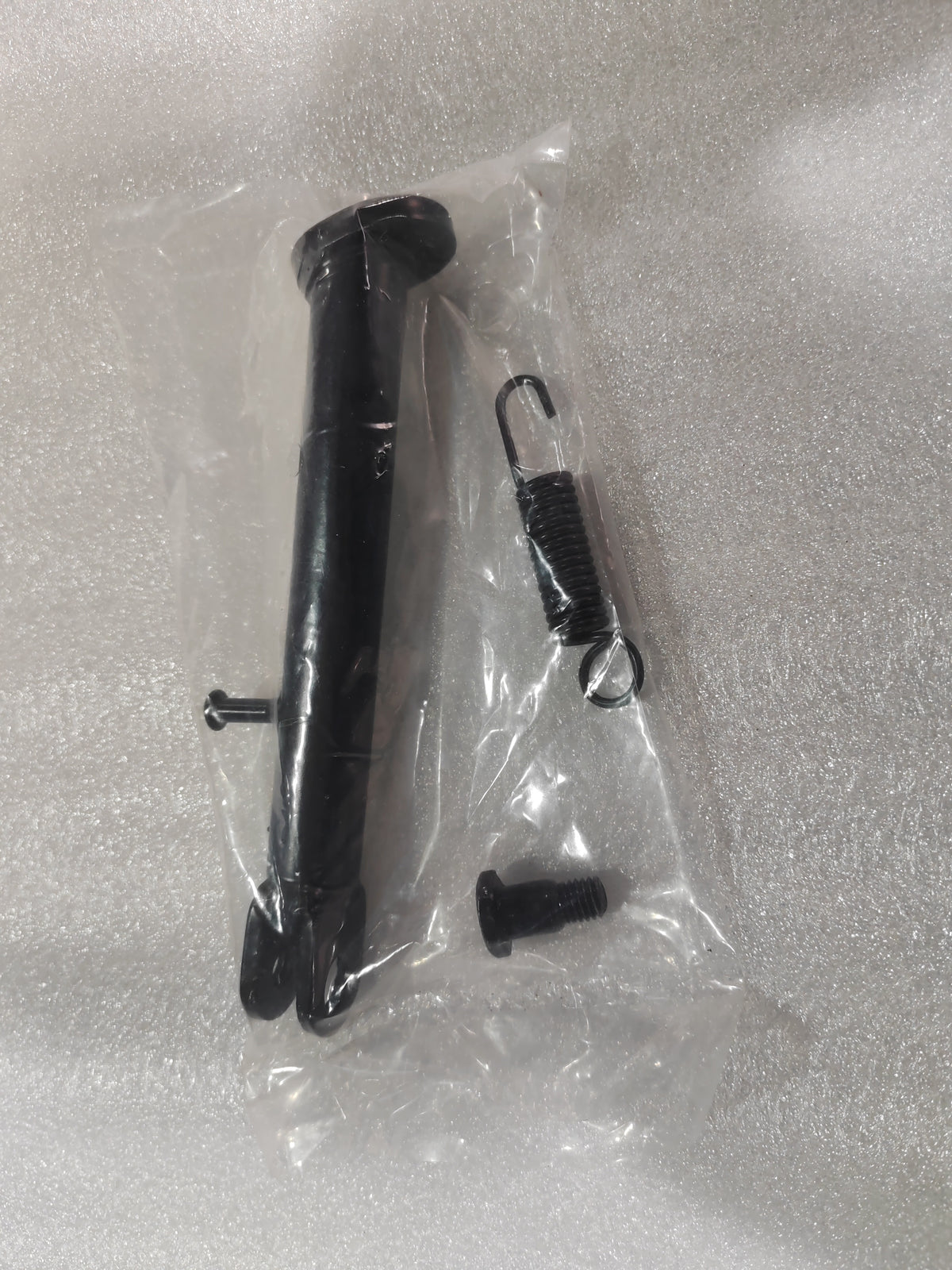 Béquille noire pour trottinette électrique Rovoron R7 fournie avec son ressort et sa vis de fixation sous emballage plastique