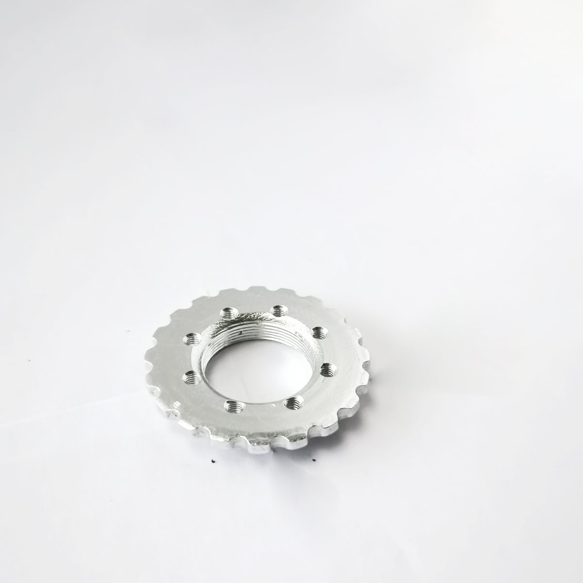 Écrou de jeu de direction cranté argenté pour trottinette Dualtron posé à plat sur un fond blanc