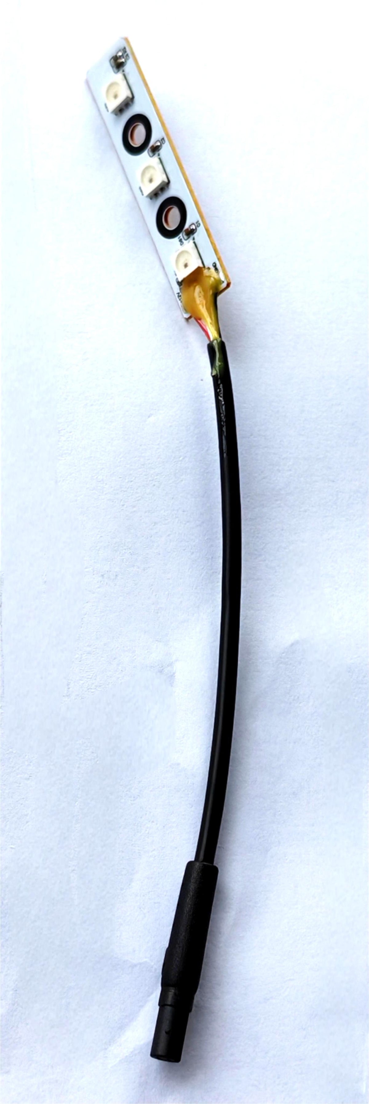 Plaque LED de bras oscillant avant droit avec son câble de connexion noir sur fond blanc