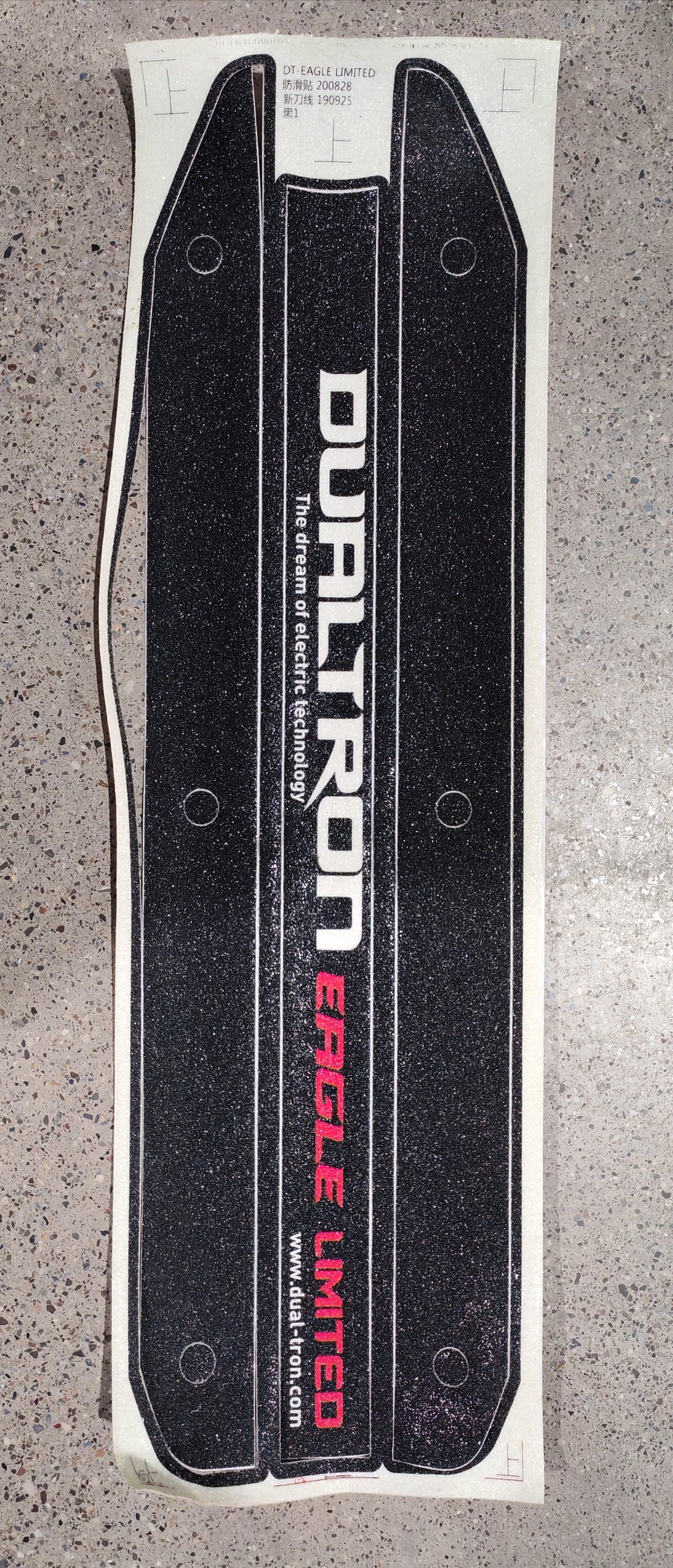 Grip antidérapant noir Dualtron Eagle Limited avec inscriptions blanches et rouges sur sa feuille de support