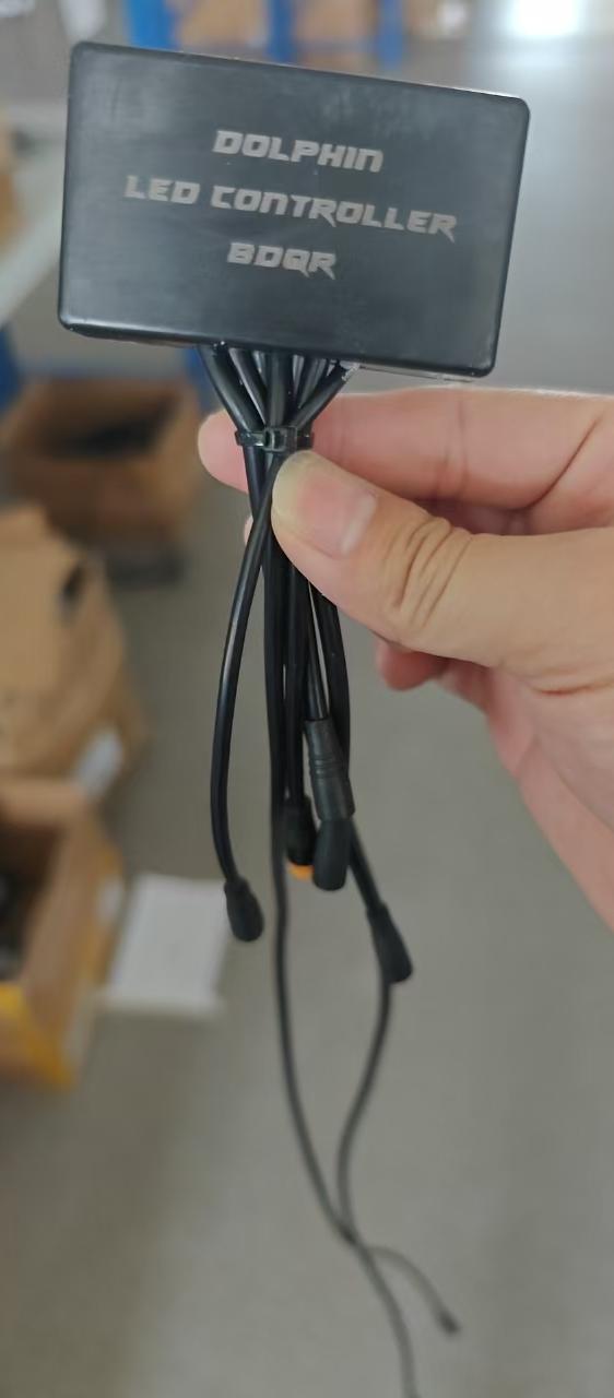 Contrôleur LED noir avec câbles de connexion pour trottinette électrique Dualtron Dolphin tenu en main