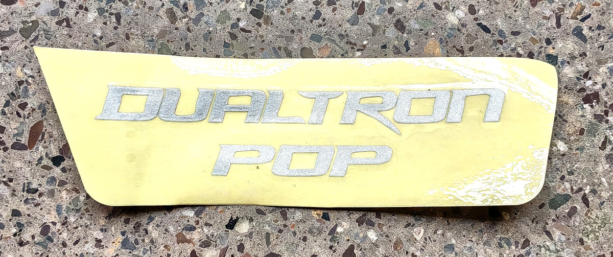 Autocollant de cache fourche avant avec le logo Dualtron Pop sur son papier protecteur