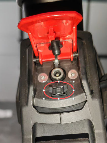 Clip noir de fermeture du capot de port de charge entouré en rouge sur une trottinette Dualtron Dolphin