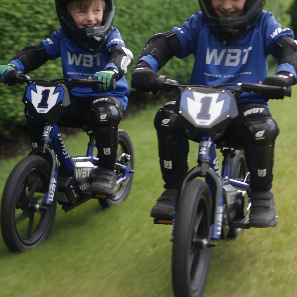 Deux enfants sur des draisiennes WBT dans un jardin